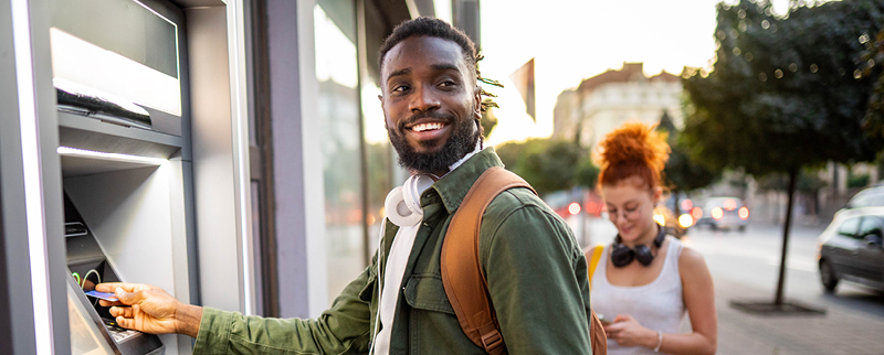 man smiling by ATM