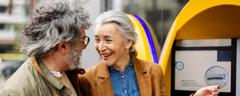 older couple smiling by ATM