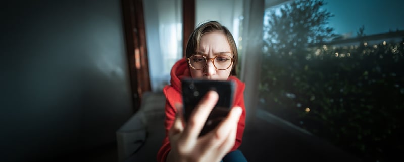 Person looking suspiciously at their phone