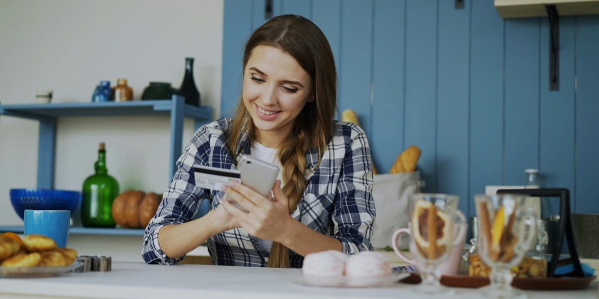 woman putting credit card details into phone